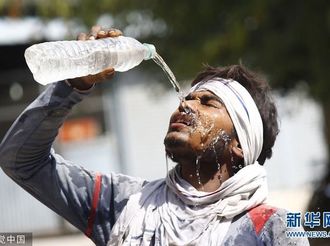 印度多地迎来高温天气 人们街头浇水降温